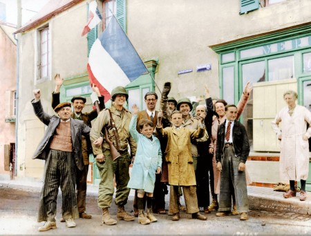  1944年6月12日，法国圣奥诺里讷镇的民众在三色旗下欢迎三名盟军（美国）大兵。(Courtesy of Marina Amaral)